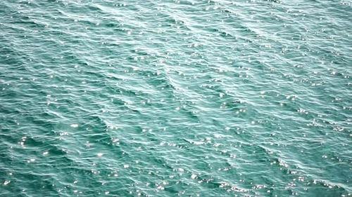 Luftaufnahme der Meereswasseroberfläche auf klarem azurblauem Meerwasser, Sonnenblendung, abstrakter nautischer Sommerozean
