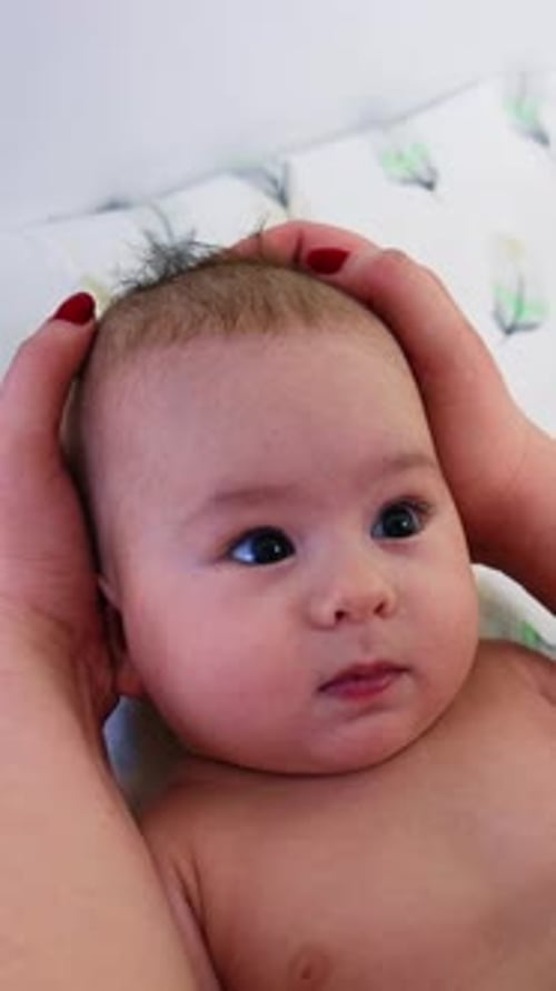 Gentle Touch: Loving Hands Caress Adorable Baby's Head