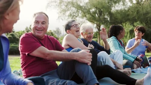 Happy senior people after yoga sport workout having fun sitting outdoors in park city