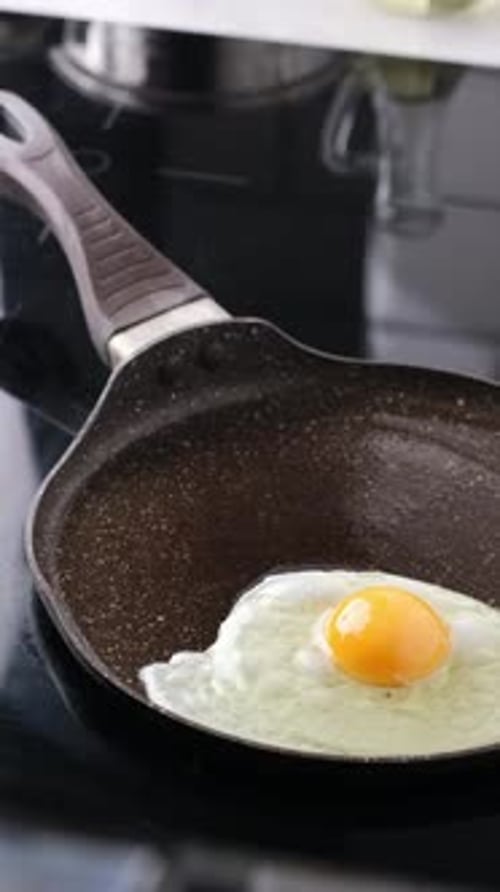 Mädchen knackt ein Ei, um Spiegeleier zu machen