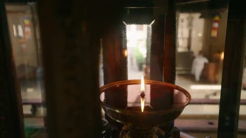 Oil Scent Lamp Burns in Buddhist Temple Flame Flickers with Serene Ambiance in Spiritual Setting