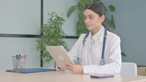 Young Female Doctor using Tablet in Clinic