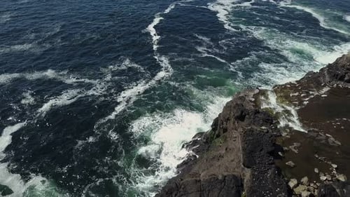 swirl around the rocky and scenic coastline, sea waves breaking over rocks