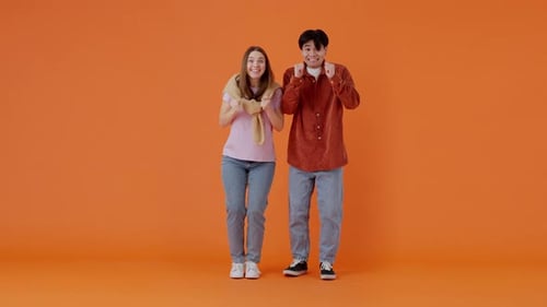 Excited Friends Celebrating Success on Orange Background