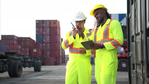 Workers Inspect Shipping Containers at Port Using Tablet