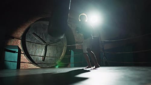 Energy of Sport Professional Fighter Training in Boxing Ring Hitting Punch Bag Cinematic Slow Motion