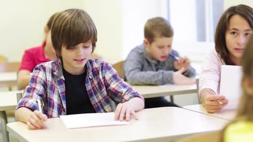 Education, Elementary School, Learning And People Concept - Group Of School Kids With Pens And Pa...