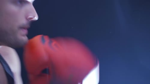 Boxer Training in Dark Boxing Ring, Close Up
