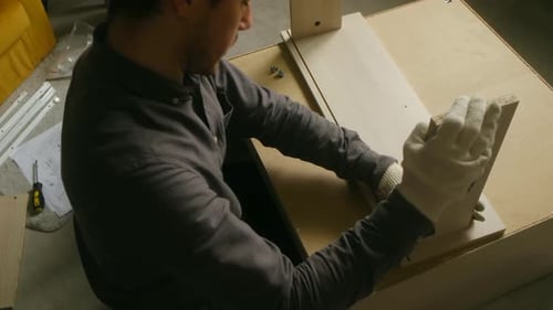Carpenter Assembling Wooden Furniture in Workshop