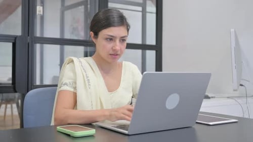 Kranke Inderin hustet, während sie ihren Laptop benutzt