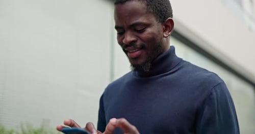 Black man, walking in city with smile and phone, typing text or checking social media post online