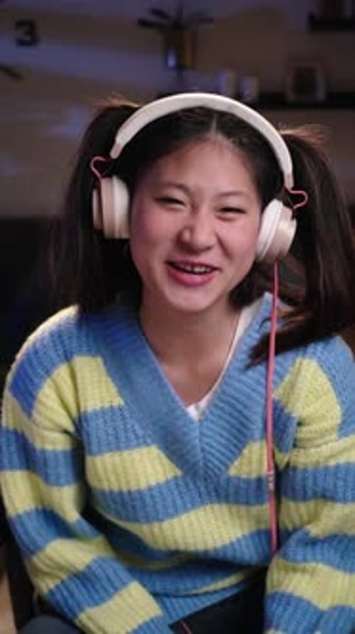Smiling Woman with Headphones Gesturing Indoors