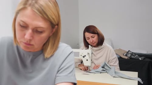 Women Sewing Textiles with Sewing Machines Indoors
