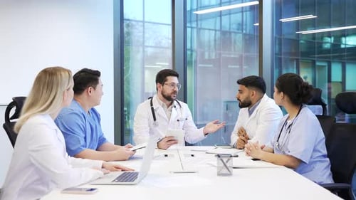 Group of doctors communicate at conference meeting in clinic office boardroom. Team of workers