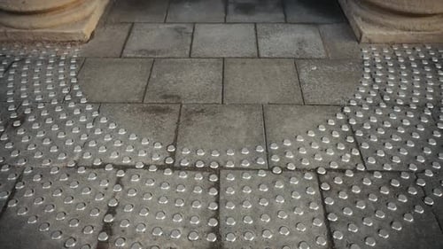 Closeup of Grey Brick Flooring with White Dots Resembling Automotive Tires