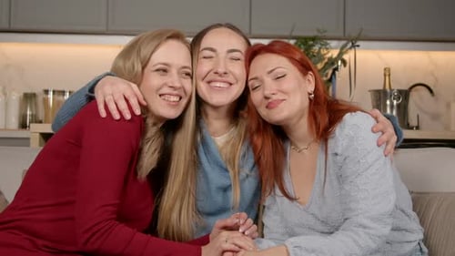 Women Embracing Happily on the Sofa