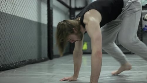 Homme en forme faisant du burpee pendant un entraînement cardio au gymnase avec housse de protection
