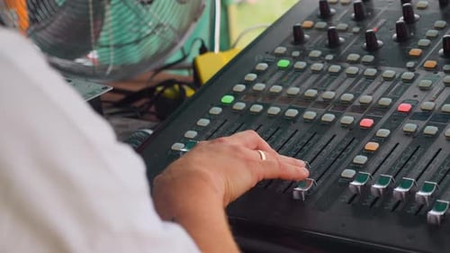 Sound engineer sliding potentiometers up, slow motion 50 fps