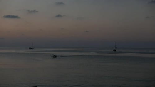 Small boats in silhouette at sunset. Mediterranean Sea. Cefalu. Sicily. Italy.