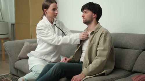 Doctor Examines Patient with Stethoscope on Sofa
