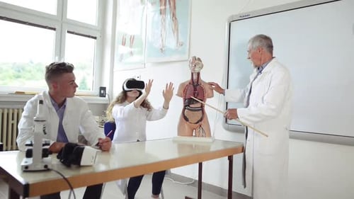 Senior teacher explaining biology to high school students in class