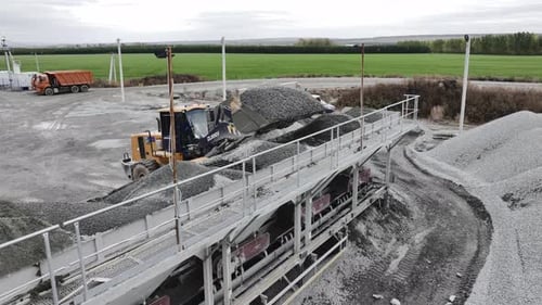 Excavator Loads Granite Grains in Sorting Machine at Quarry