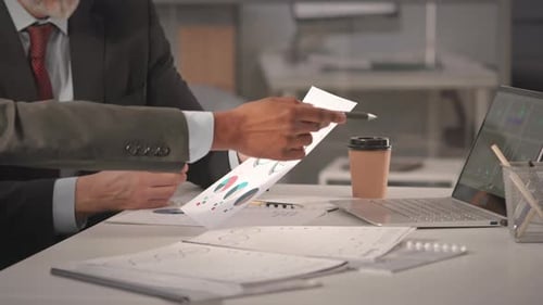 Business Colleagues Reviewing Financial Charts at Desk