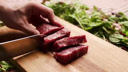 Meat Being Sliced On A Cutting Board