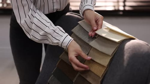 Woman Choosing Neutral Fabric Swatches for Upholstery