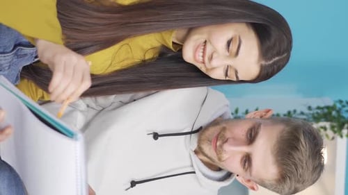 Young Couple Smiling and Working Together at Home