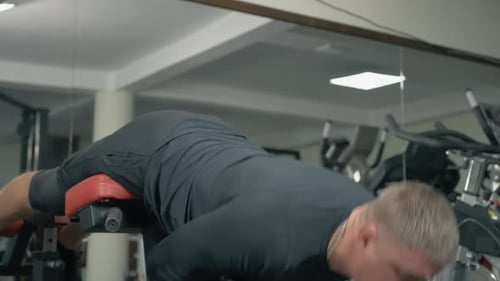 Bodybuilder Trains Lower Back Muscles in a Fitness Club