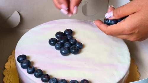 Woman Decorating Cake with Fresh Blueberries