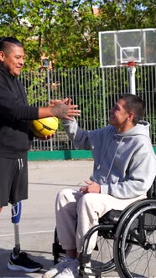 Two Young Men Talk on Urban Basketball Court