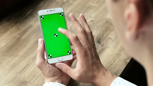 Ein moderner Geschäftsmann verwendet das Handheld-Handy mit Greenscreen-Chromakey und gestikulierender Nahaufnahme