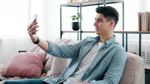 Young Man Chatting on Cell Phone at Home