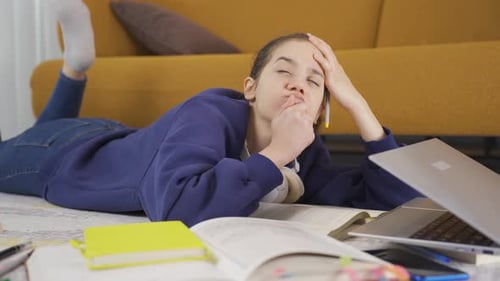 Teenage Student Studying on Floor with Laptop and Books