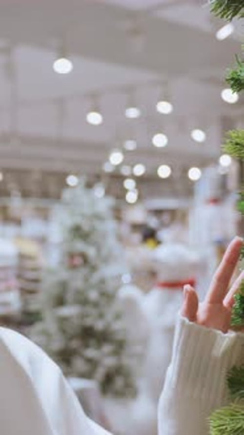 Young Woman Smiling While Touching Decorative Tree in Store