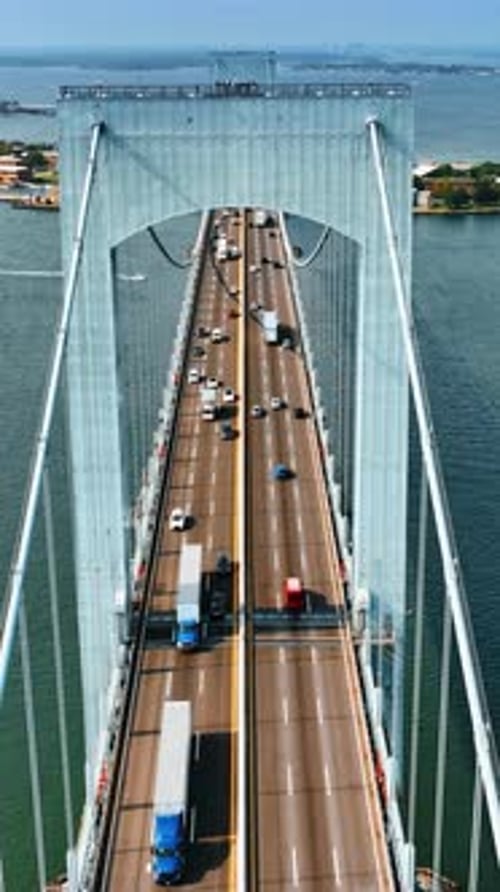 Footage above the bridge along the roads with cars. Many boats on the water. Top view.