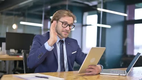 Man in Suit Using Tablet for Video Call