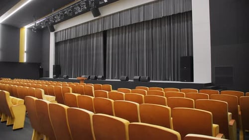 Chair Rows and Stage with Black Curtain in Theatre
