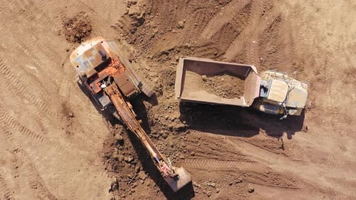 Excavator Fills Dump Truck with Soil Aerial View
