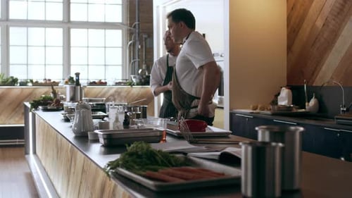 Chefs arrive at kitchen cooking station for food preparation with soft day lighting