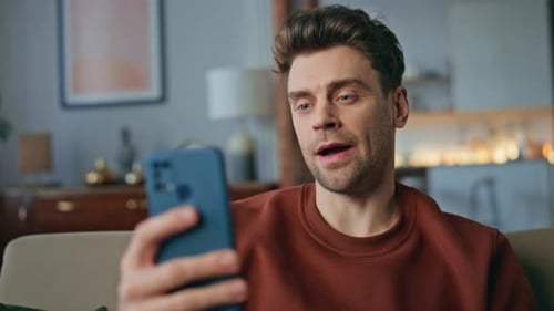 Serious Man Talking Webcam Chat By Smartphone on Couch Close Up Guy Video Call