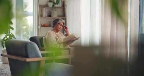 Senior Woman Reading Book in a Living Room