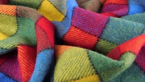 Top view of the soft folds of the bright textured multicolored wool fabric rotated