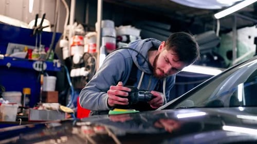 the Car Mechanic at a Service Station Doing the Final Polishing to Shine