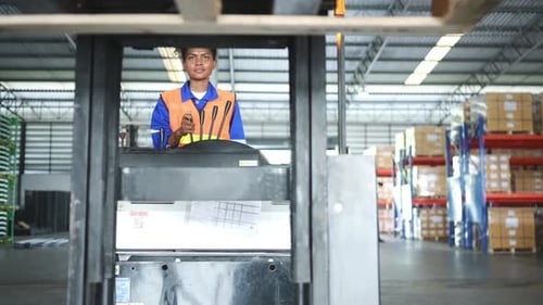 Worker in auto parts warehouse use a forklift to work to bring the box of auto parts