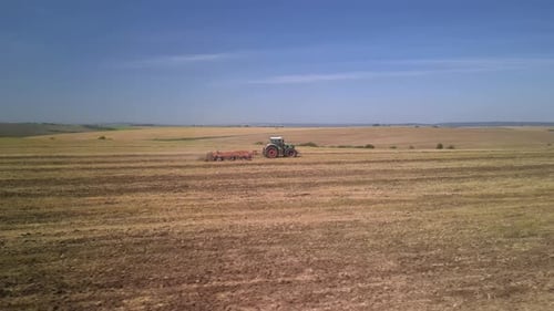 Tractor working on the field doing tillage with cultivator