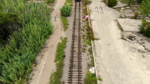 Une écurie en hauteur prise par un Drone d'un train de transport transportant du charbon avec des plantations le long de la voie latérale