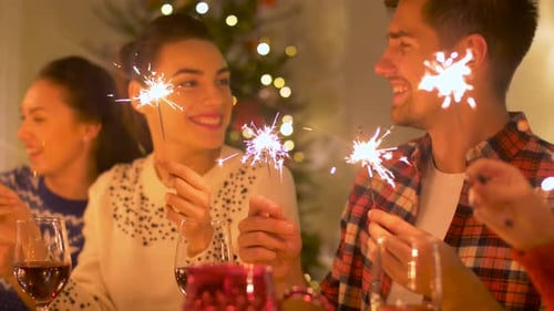 Friends Celebrate Holidays with Sparklers and Wine Indoors